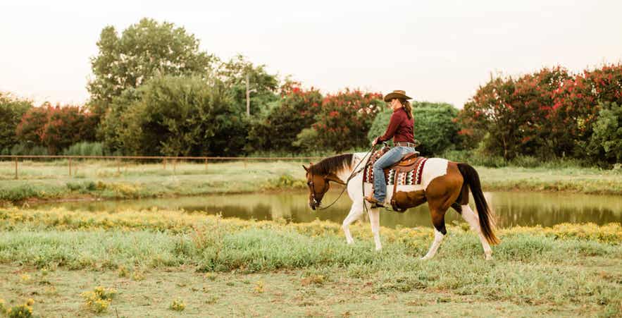 Woman riding horse outdoors.