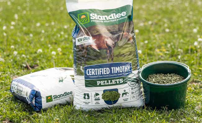Two bags and a bowl of Certified Timothy Grass Pellets