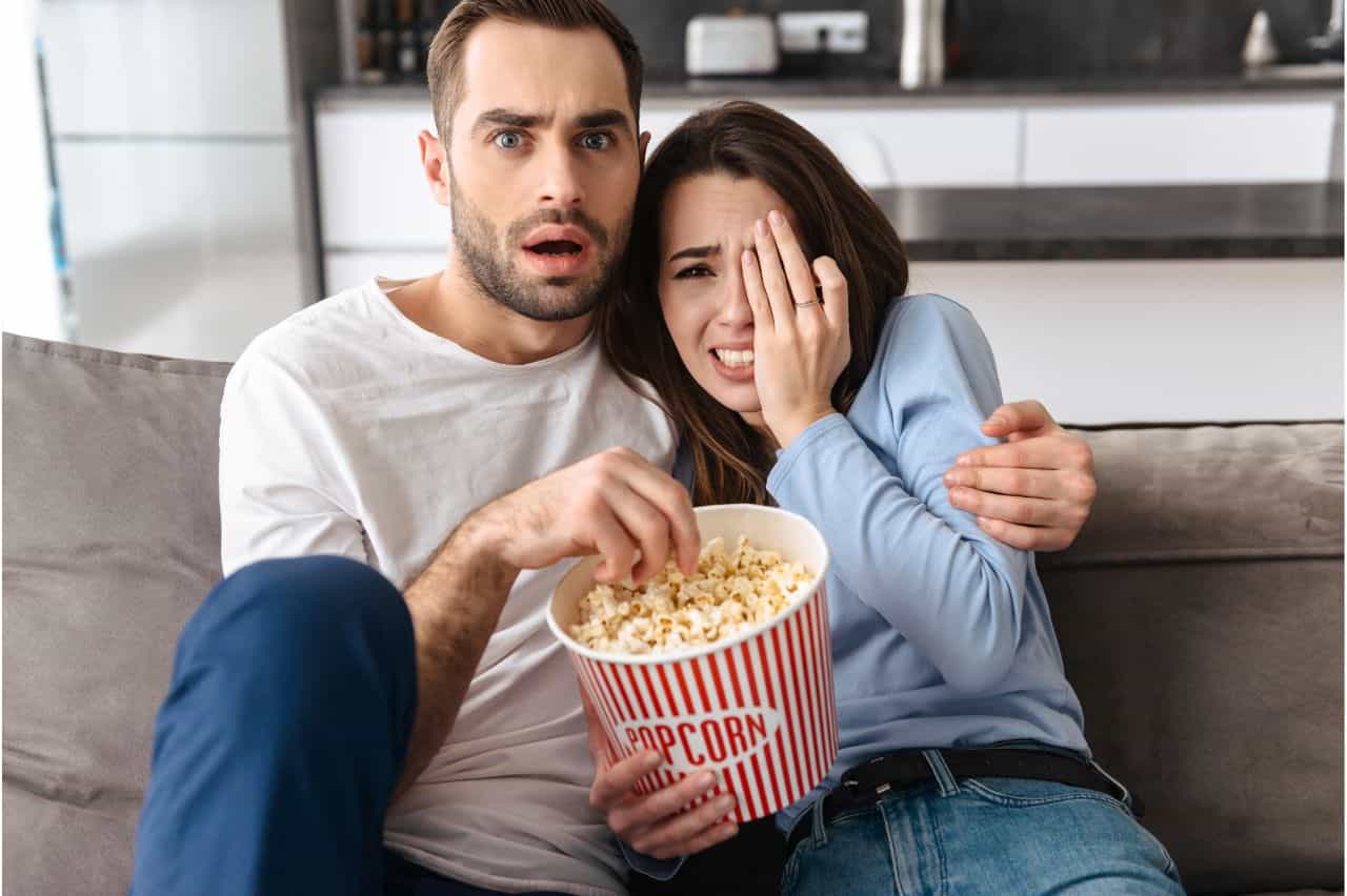Couple with popcorn watching something scary