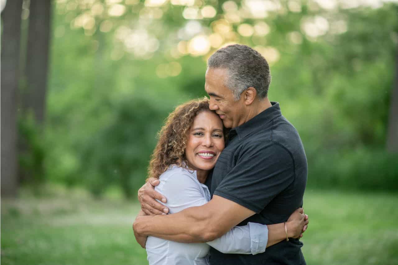 Woman embracing husband with big smile
