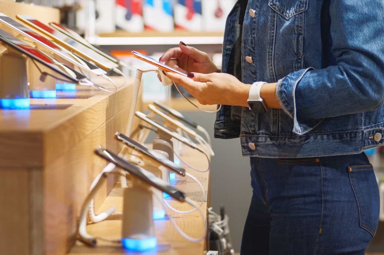 Hands trying a phone from the display row