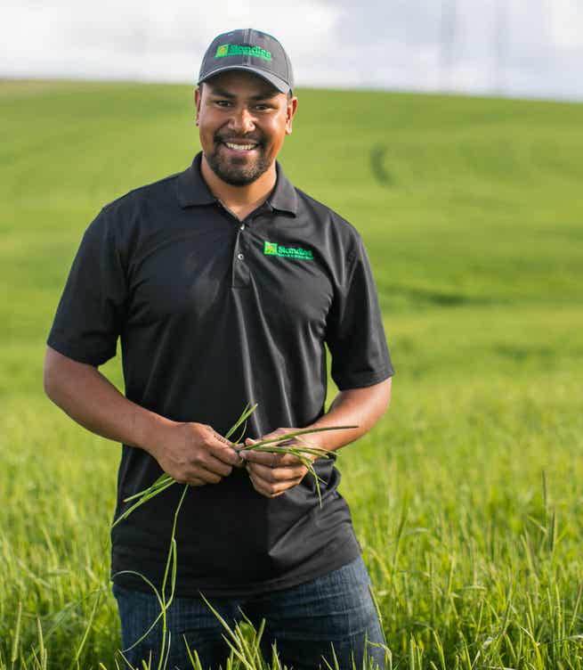 Man in a field holding forage